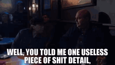 a man sitting at a table talking to another man with the words well you told me one useless piece of shit detail