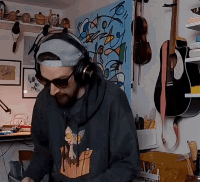 a man wearing headphones stands in front of a painting