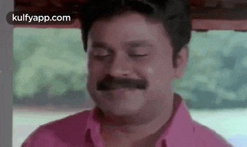 a man with a mustache is making a funny face .