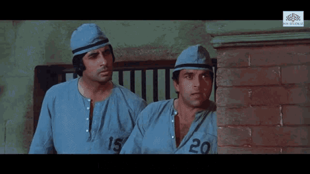 two men in prison uniforms with the number 15 and 20 on their shirts