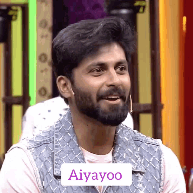 a man with a beard is wearing a denim vest and the word aiyayoo is on the front