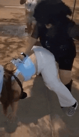 a woman in a mask is being held by a man in a black shirt .