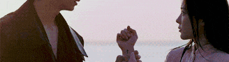 a man and a woman are looking at each other and holding hands
