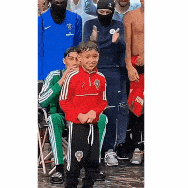 a boy wearing a red jacket with the letter r on the front