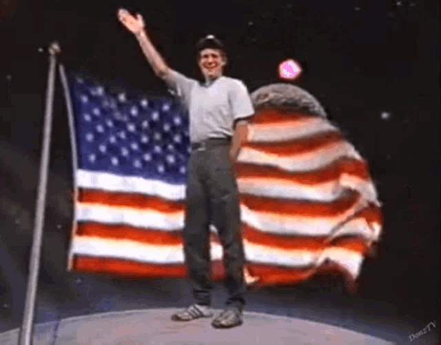 a man stands in front of an american flag and waves