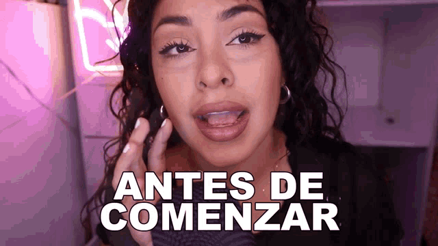 a woman says antes de comenzar in front of a pink background