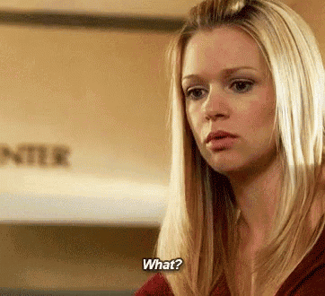a woman with blonde hair is asking what while wearing a red shirt