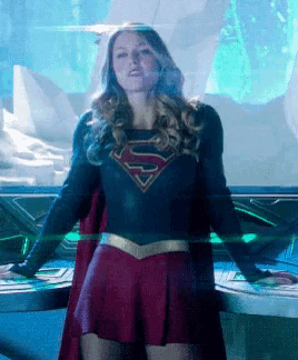 a woman in a superman costume is standing in front of a glass wall