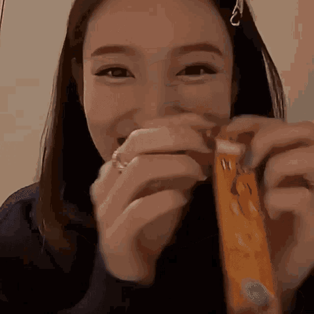 a woman with a ring on her finger is holding a candy bar in her hands