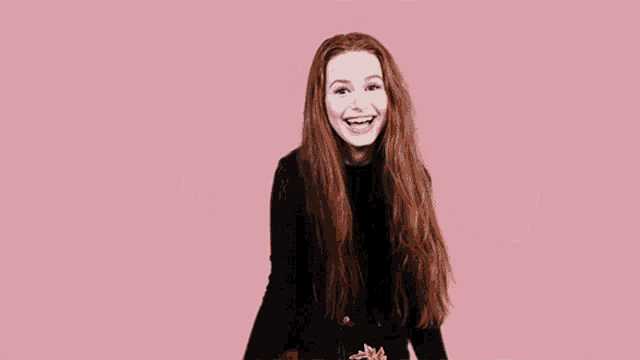 a woman with red hair is wearing a black crop top and black shorts