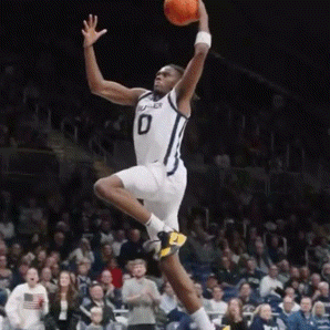a basketball player wearing a number 0 jersey is jumping in the air