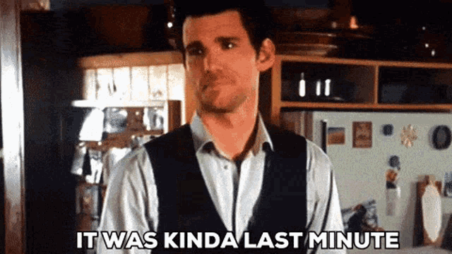 a man in a vest is standing in a kitchen and says it was kinda last minute