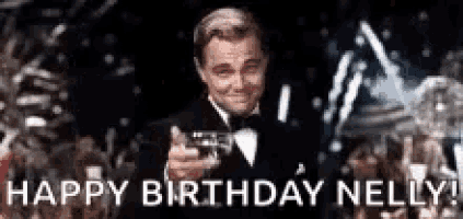 a man in a tuxedo is pointing a gun at the camera and saying `` happy birthday nelly ! ''
