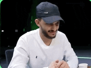 a man with a beard is wearing a black hat and a white shirt .