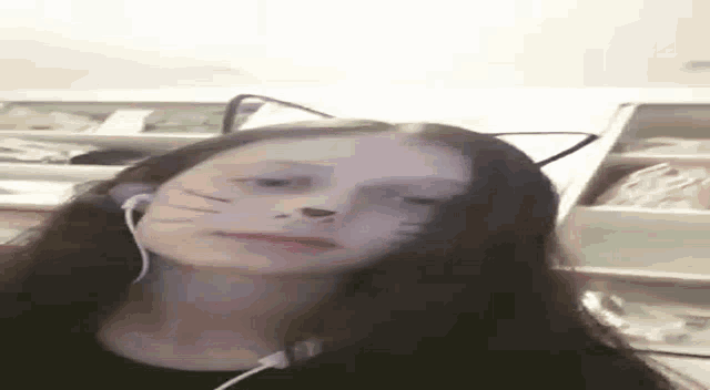 a woman wearing cat ears and headphones is making a face .
