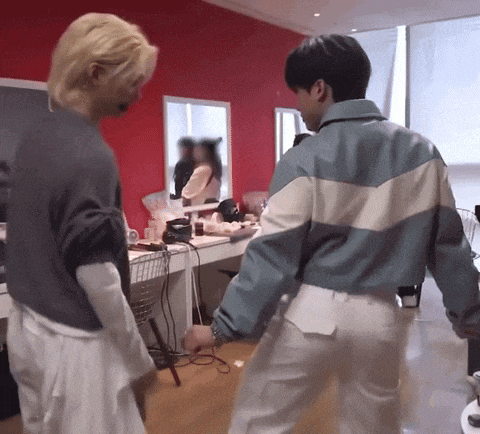two men are standing next to each other in a room