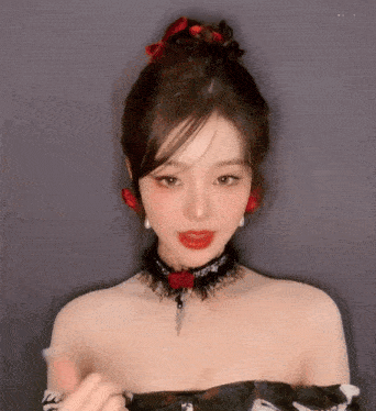 a woman wearing a choker necklace and earrings looks at the camera