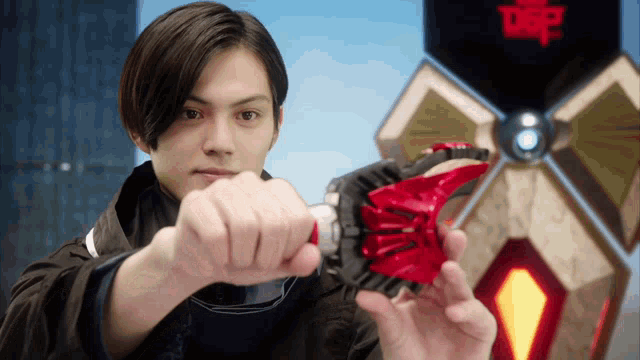 a man is holding a red object in front of a sign that says dsp on it