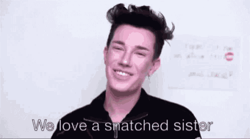 a man in a black jacket is smiling and says `` we love a snatched sister '' .