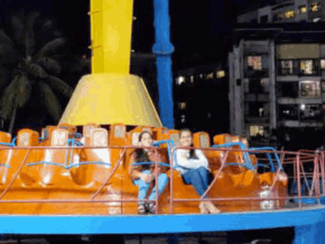 a couple of people sitting on a ride at night