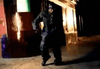 a man is dancing in front of a building at night .
