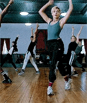 a group of people are dancing in a gym .