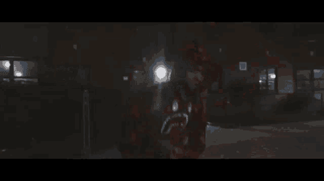 a man in a red plaid shirt is walking down a dark street at night .