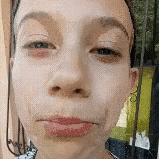 a close up of a woman 's face with a red eye and a pink lip .
