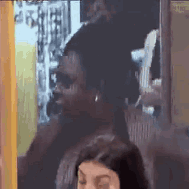 a man and a woman are looking at each other in a room .
