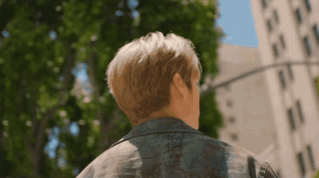 the back of a man 's head is shown in front of a building