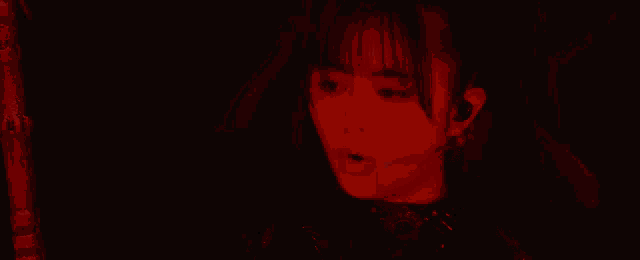 a close up of a woman 's face in a dark room with her eyes closed .