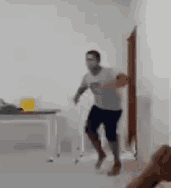 a man is standing in a room with a cane and a walker .