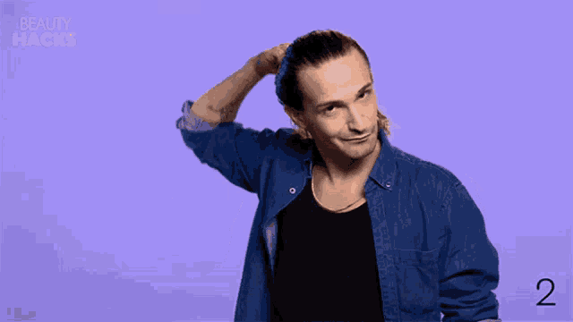 a man in a denim shirt scratches his head in front of a beauty hacks logo