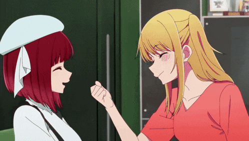 a girl with red hair is touching another girl 's face