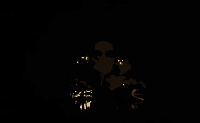 a dark room with a reflection of a light bulb