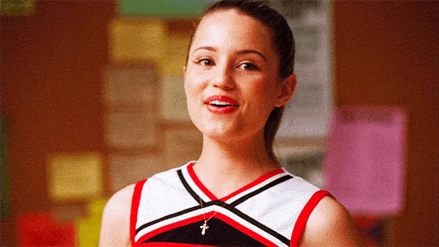 a cheerleader with a cross necklace is smiling