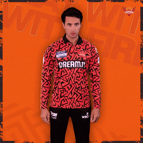 a man wearing a red and black shirt that says dream on it