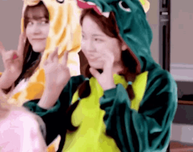 a woman in a dinosaur costume is making a funny face .