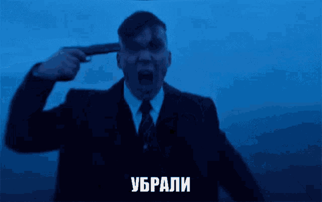 a man in a suit and tie is holding a gun to his head with the word ukrai on the bottom right