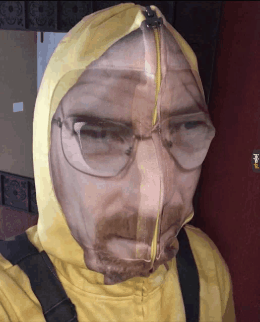 a man wearing glasses and a yellow hoodie has a picture of a man 's face on his face