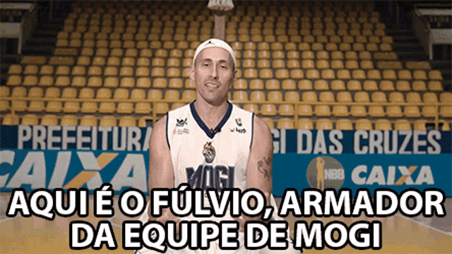 a man in a mogi jersey stands in front of an empty bleachers