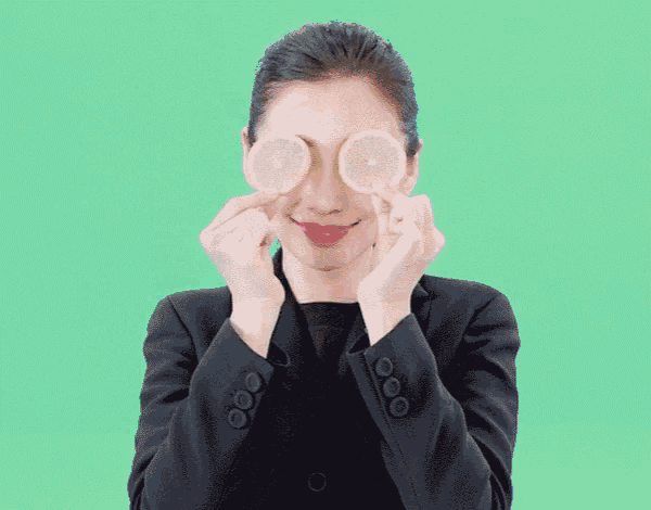 a woman in a suit is holding a heart shaped candy in her hands