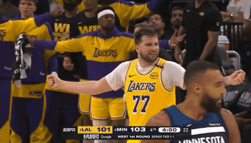 a basketball player wearing a lakers jersey stands in front of a crowd