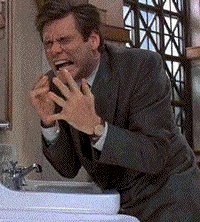 a man in a suit is sitting in front of a sink making a face
