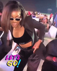 a woman wearing sunglasses is dancing in front of a sign that says let 's go !