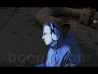 a man wearing headphones is sitting in front of a screen that says booooojour