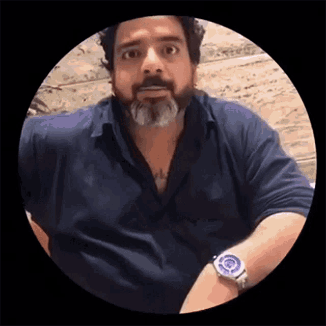 a man with a beard is wearing a watch