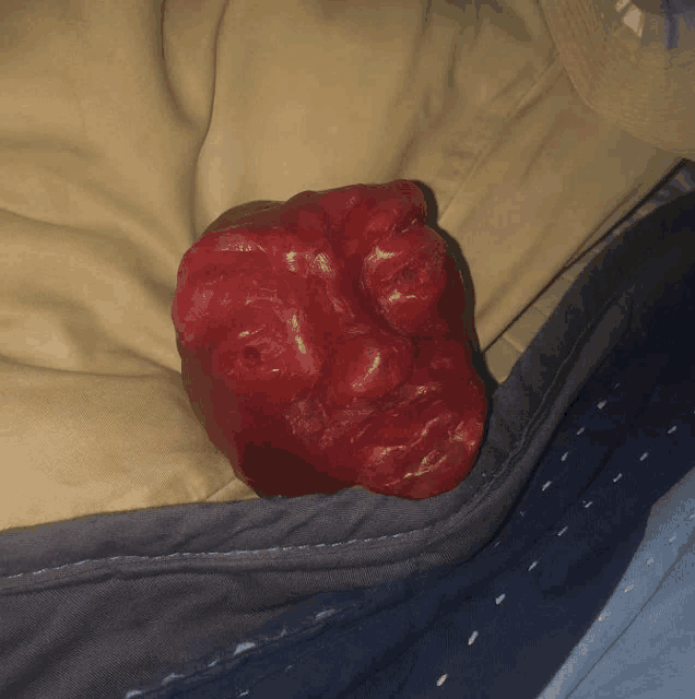 a red statue of a face is laying on a blanket