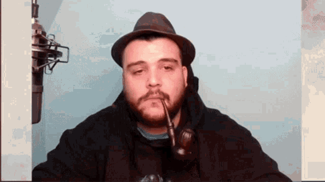 a man with a beard wearing a hat and smoking a pipe