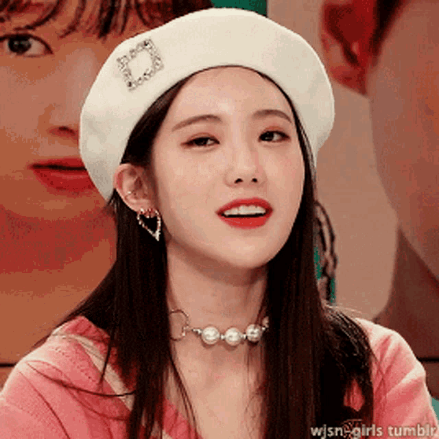 a woman wearing a white beret and a pink shirt has a picture of another woman in the background